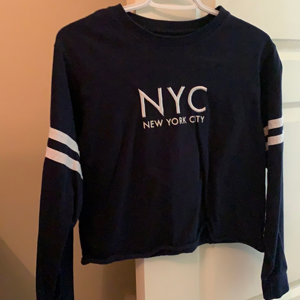 Navy sweatshirt, striped on arms, cropped.